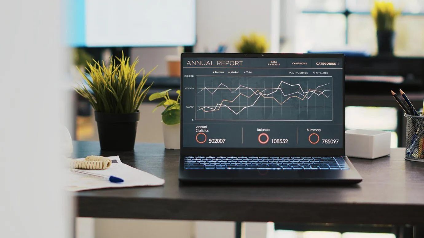 A laptop on a desk displaying an annual report dashboard