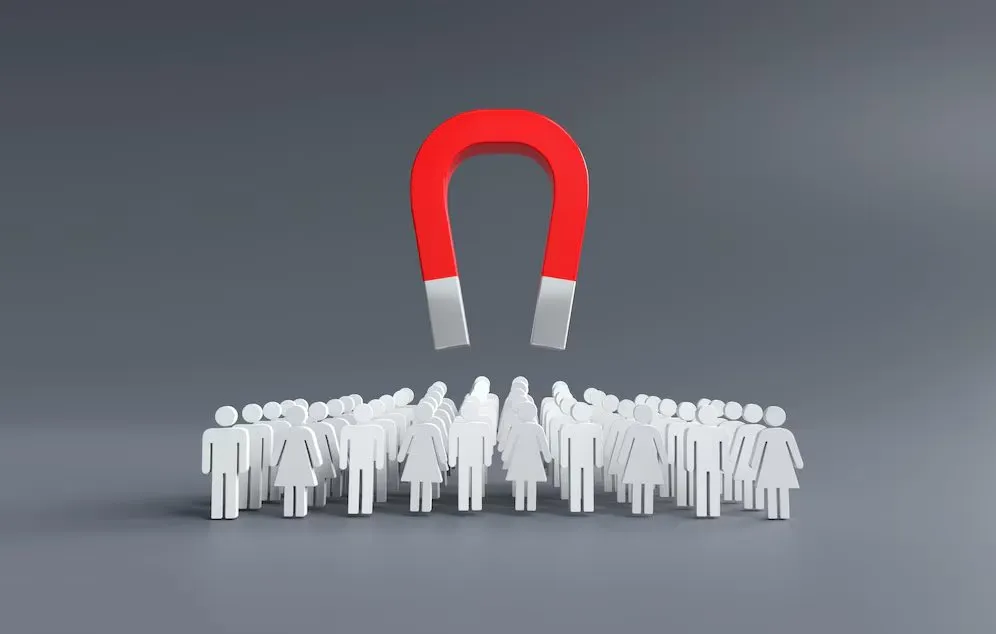 A large red magnet drawing in a crowd of small white figures